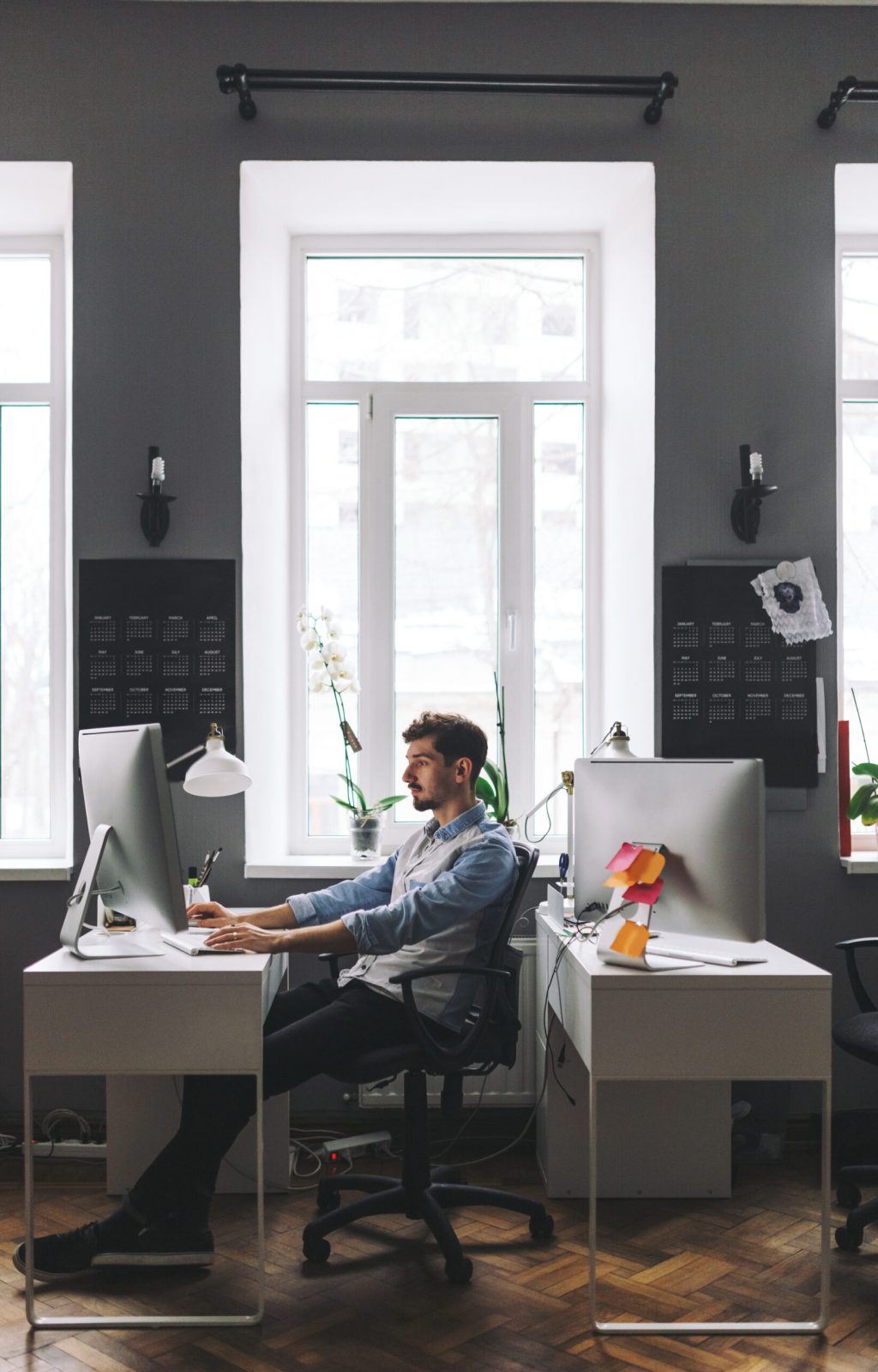 Young man working on computer while sitting at his working place in office